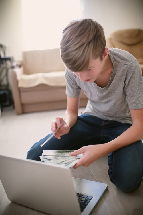 a-teenager-holding-a-fan-of-dollar-bills-in-his-ha-2024-12-03-08-23-59-utc
